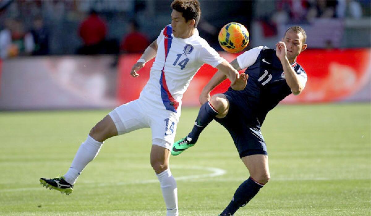 The United States' Brad Davis, right, keeps the ball away from South Korea's Lee Yong during a Feb. 1 friendly match at StubHub Center. The U.S. defeated South Korea, 2-0.