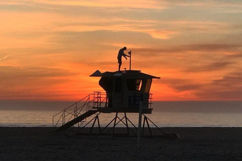 HUNTINGTON BEACH, CALIF. -- THURSDAY, JANUARY 18, 2018: With a scenic sunset view, Vitaliy Kostylov installs Wi-Fi and solar panels on lifeguard towers at Huntington State Beach in Huntington Beach Thursday, Jan. 18, 2018. (Allen J. Schaben / Los Angeles Times)