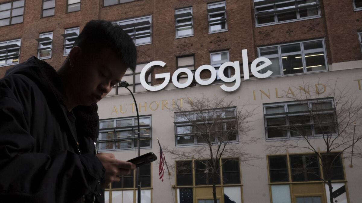 A man using a mobile phone walks past Google offices in New York in December.