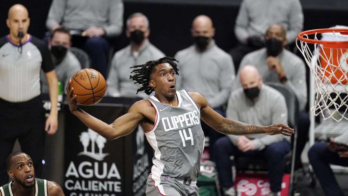 Clippers guard Terance Mann goes up for a shot past Bucks forward Khris Middleton.