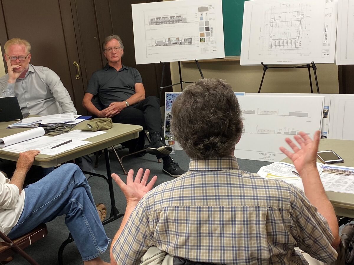 La Jolla Development Permit Review Committee chair Brian Will, left, listens as trustee Mike Costello, right, objects to the mixed-use residential and commercial project that owner David Bourne proposes for 801 Pearl St.