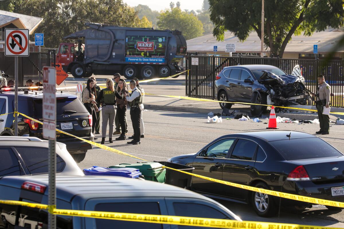 Sheriff's deputies and others stand near a crash site in South Whittier.