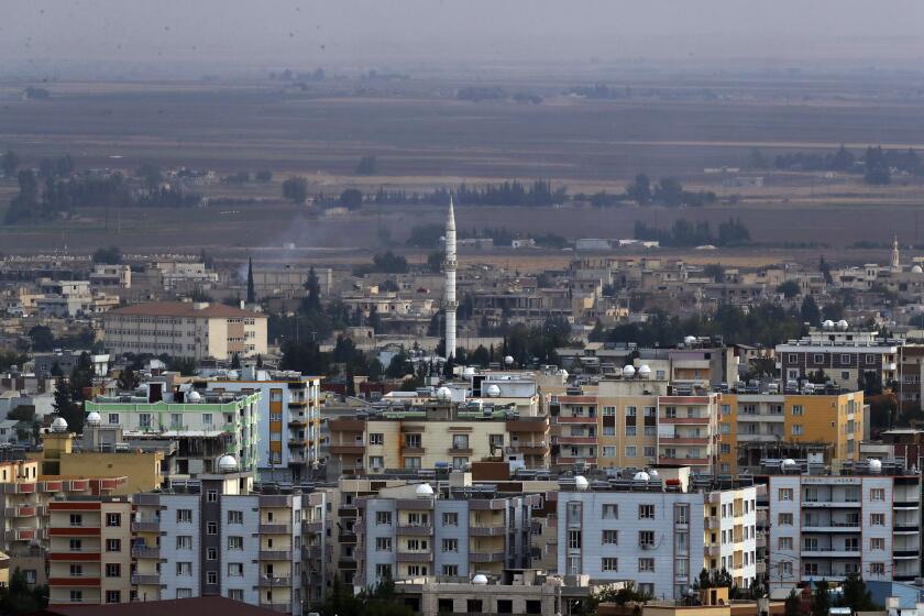 In this photo taken from the Turkish side of the border between Turkey and Syria, in Ceylanpinar, Sanliurfa province, southeastern Turkey, a new of Ras al-Ayn, Syria, Friday, Oct. 18, 2019. Fighting broke out in the morning hours in the Syrian border town which has been a flashpoint in the fight between Turkey and Kurdish forces despite a U.S.-brokered cease-fire that went into effect overnight. The fighting died down in mid-morning. (AP Photo/Lefteris Pitarakis)