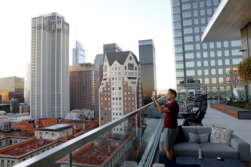 A person on a roof holds up a phone.