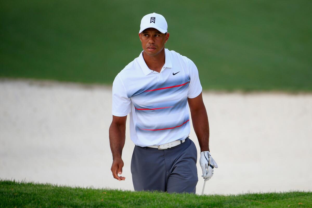 Tiger Woods climbs out of the bunker after a shot on the tenth hole of the first round of the Masters at Augusta National.