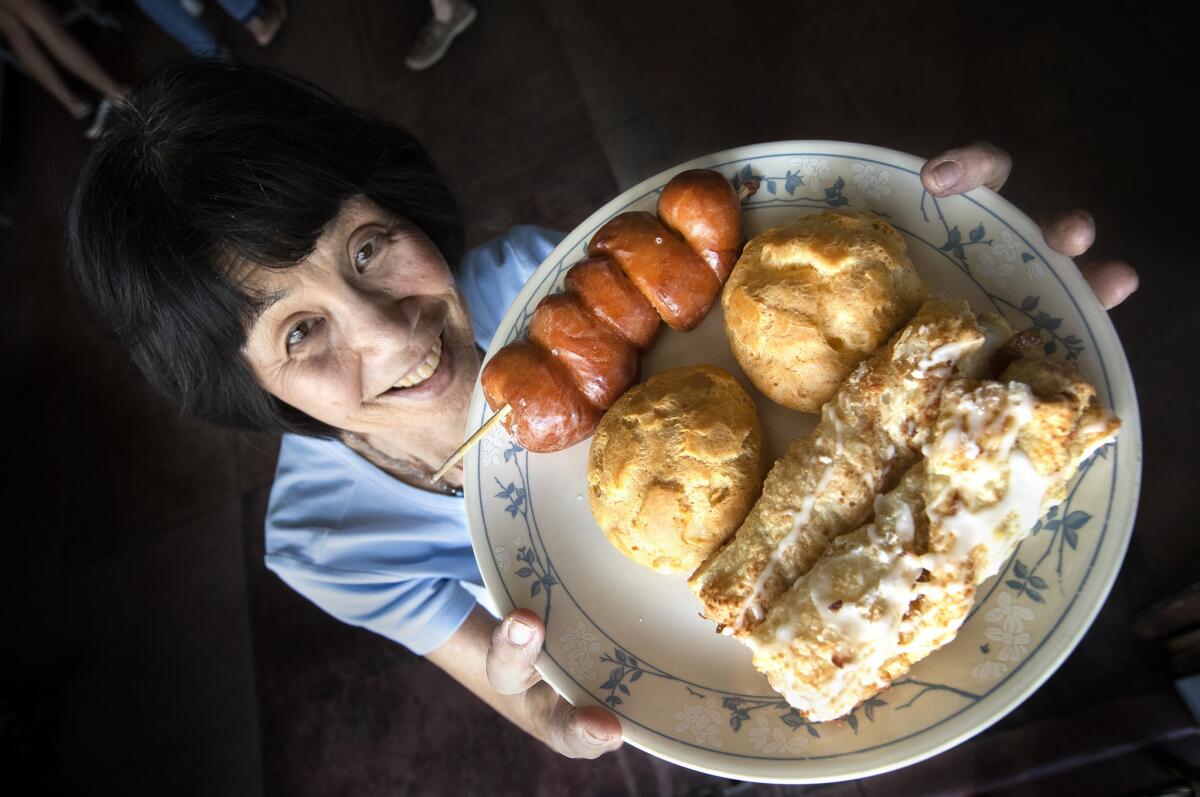 Betty Shibuya, assistant manager and granddaughter of the founders of the Komoda Store & Bakery in Makawao, Hawaii, holds up a plate of fresh baked items.