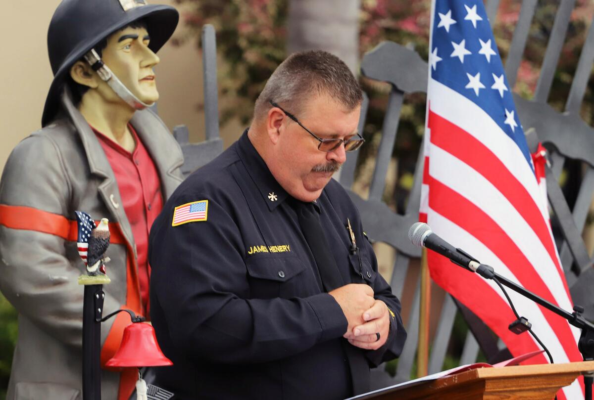 Orange County Division Fire Chief Jim Henery reads his speech Sunday at the Walk to Remember Memorial service in Santa Ana.