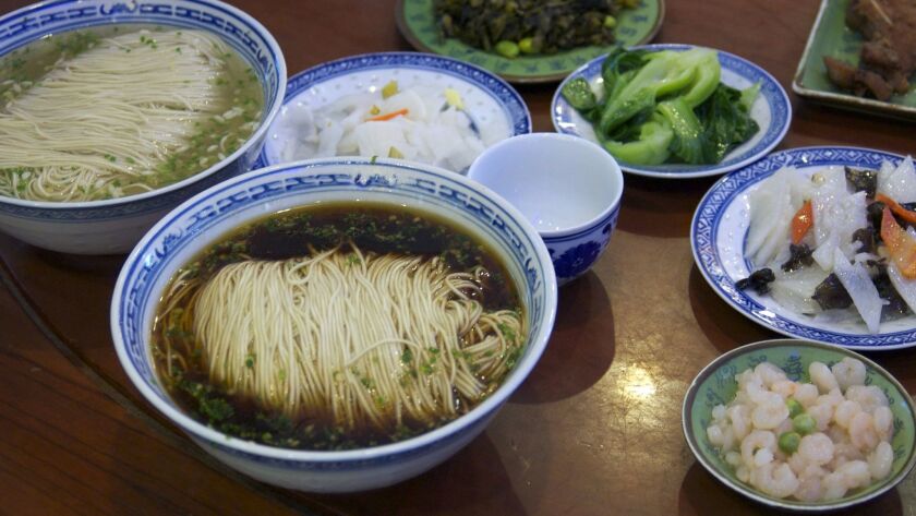TongDe Xing Noodle Shop sert un monticule de nouilles tissées serrées, lâchées dans un bouillon sombre et vaporeux. Il peut être commandé avec du poisson frit ou du porc mijoté.