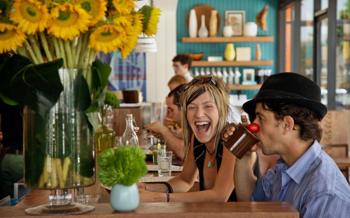 Adey Bell shares a laugh with Alexander Polinsky at the counter at Cafe Gratitude in Larchmont Village. A Cafe Gratitude is set to open downtown in 2015.