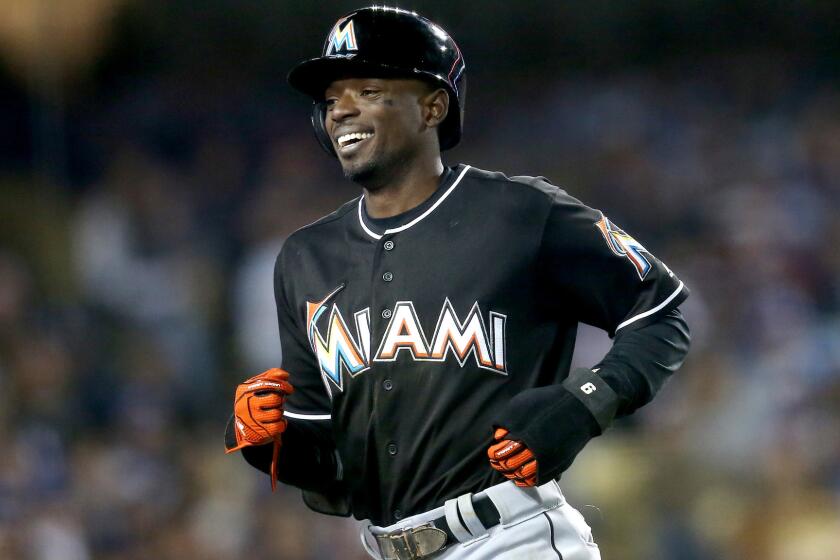 Marlins second baseman Dee Gordon returns to the dugout after scoring a run against the Dodgers on a balk in the seventh inning Thursday night.