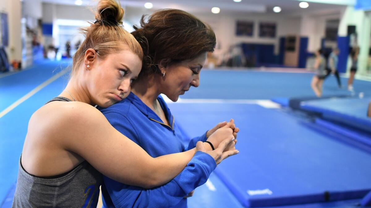 UCLA coach Valorie Kondos Field blows on the finger of gymnast Gracie Kramer she injured her nail during practice at Pauley Pavilion in March.