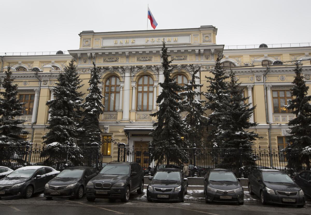 FILE - Cars are parked in front of Russia's Central Bank building in Moscow, Russia, Jan. 30, 2015. Prices for Russian credit default swaps — insurance contracts that protect an investor against a default — plunged sharply overnight after Moscow used its precious foreign currency reserves to make a last minute debt payment on Friday April 29, 2022. (AP Photo/Alexander Zemlianichenko, File)