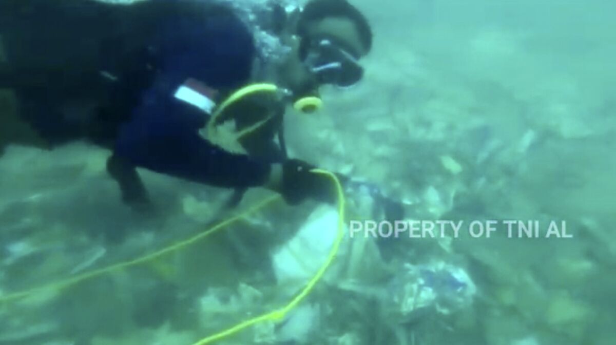 Divers recovering debris strewn on the sea floor in Java Sea 