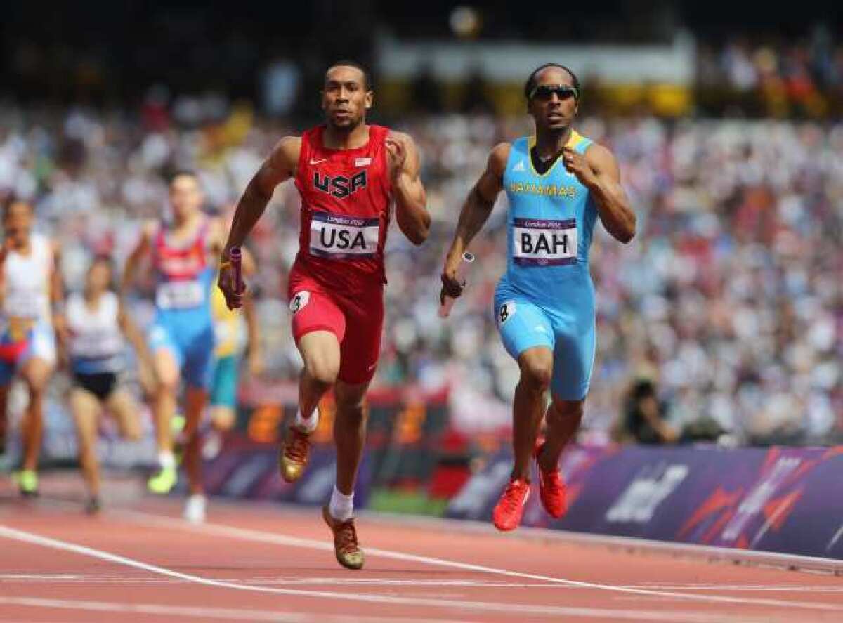 Bryshon Nellum, left, of the U.S. and Chris Brown of the Bahamas cross the finish line at the same time.