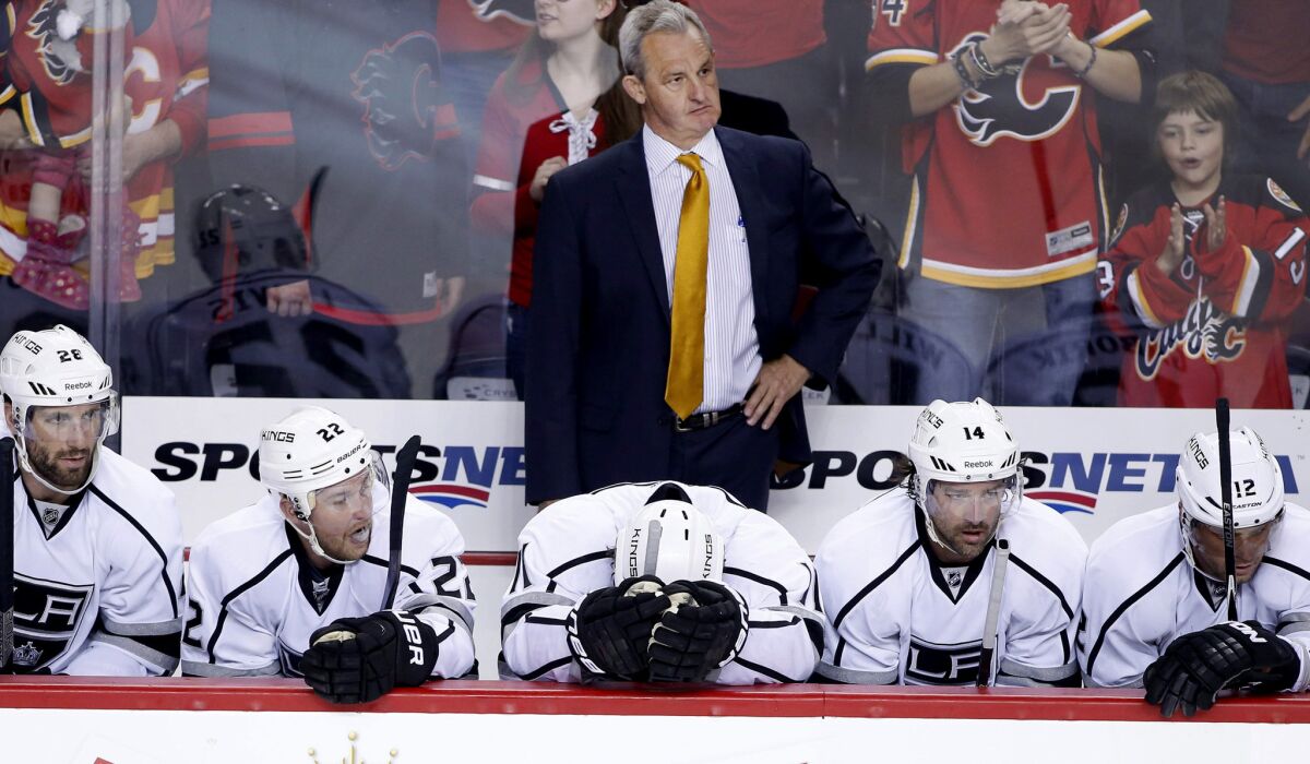 Coach Darryl Sutter and Kings players on the bench react after the Flames scored an empty-net goal to finish off a 3-1 victory on Thursday night in Calgary.
