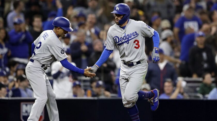 Chris Taylor is congratulated by Dodgers third base coach Dino Ebel after hitting a home run earlier this season.