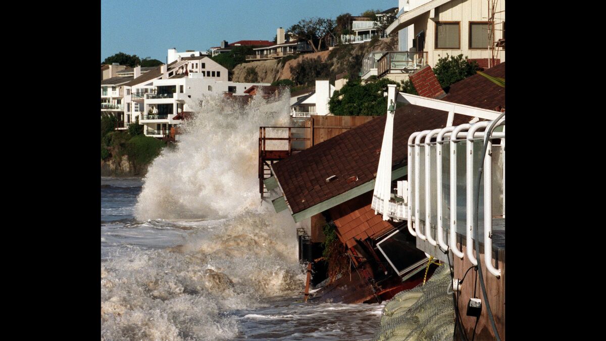 Waves crash into homes along Broad Beach in Malibu .