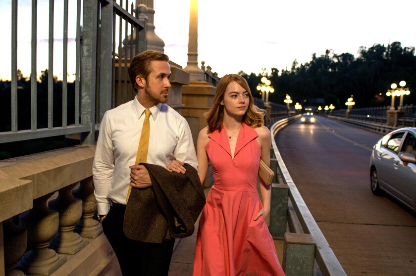 A man and a woman walk across a bridge arm-in-arm.