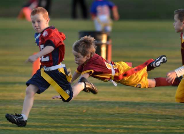 Riley Witte, left, of the Arizona Wildcats runs with the ball as Matt Wood (14) of the USC Trojans dives for the flag.