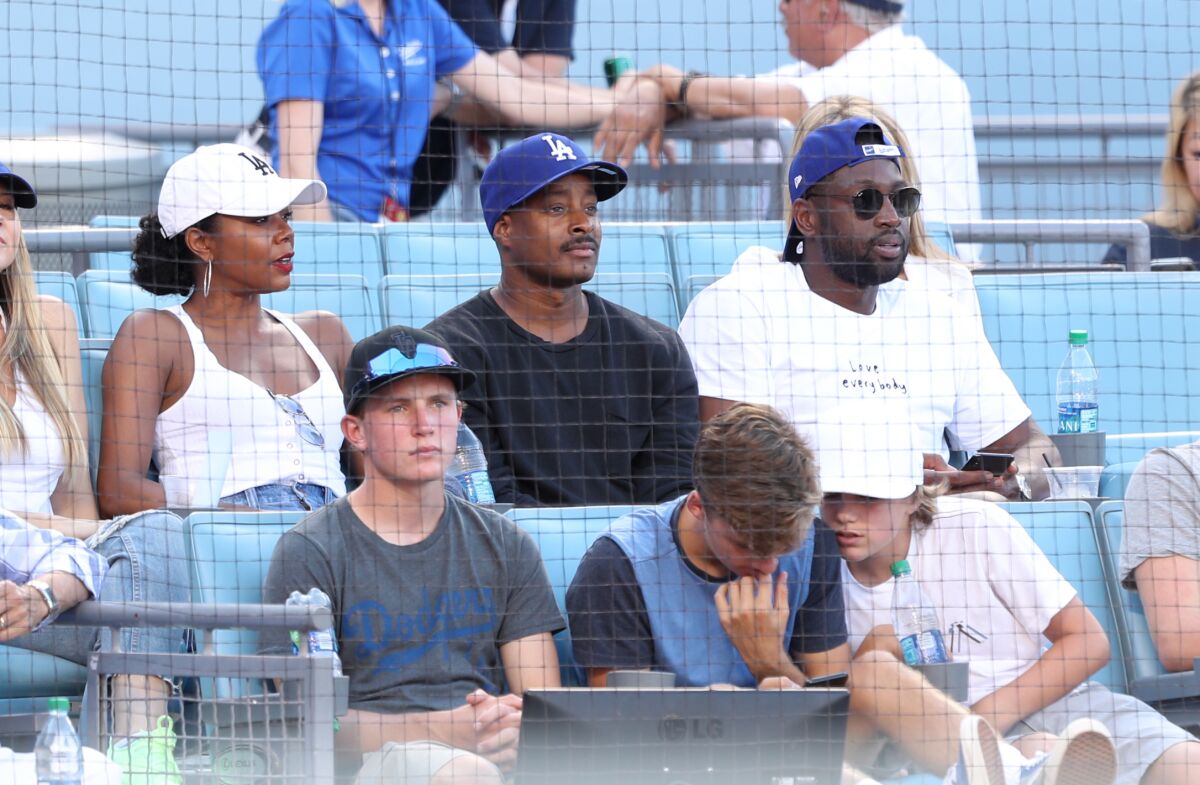 Former NBA star Dwyane Wade, right, attends a Dodgers game Aug. 25 along with his wife, actress Gabrielle Union, and interior designer Adair Curtis.