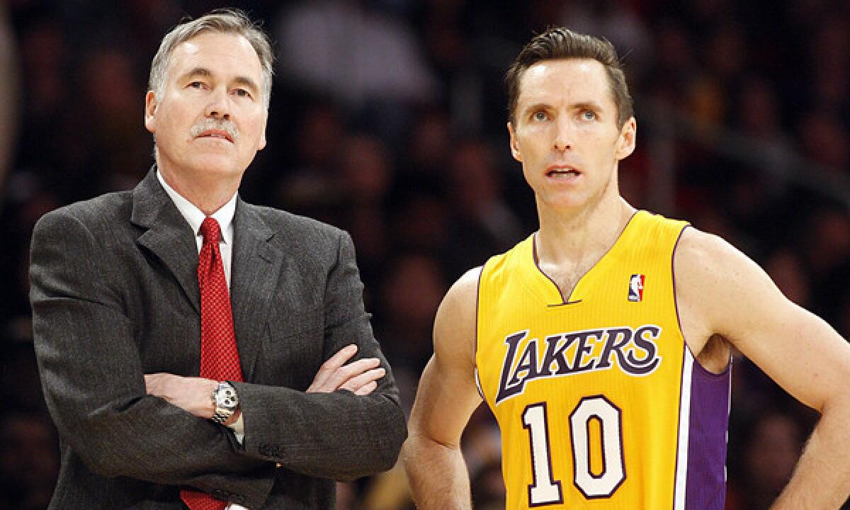 Lakers Coach Mike D'Antoni, left, and guard Steve Nash talk during a game against the Philadelphia 76ers this season. D'Antoni doesn't expect Nash to play Sunday against the Orlando Magic.