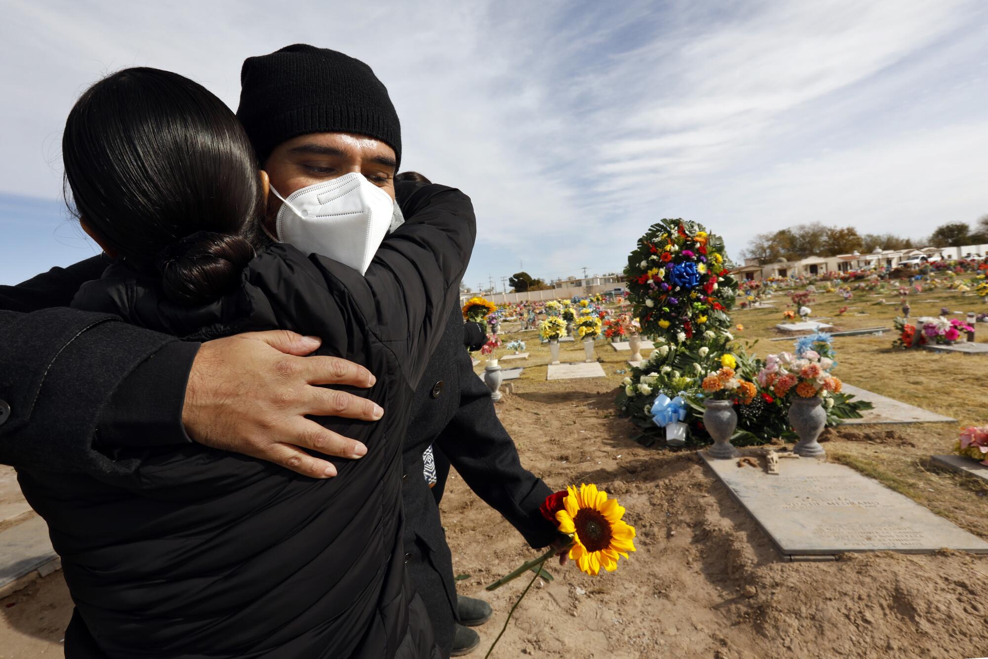 Manuel Lucio, 36, gets a hug after the burial of his father, Jose Manuel Lucio.