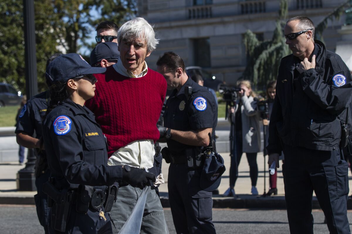 Actor Sam Waterston is detained by U.S. Capitol Police officers during a rally on Capitol Hill in Washington Friday.