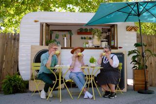 Three Swedish people sit at a bistro table drinking coffee outside a coffee cart.
