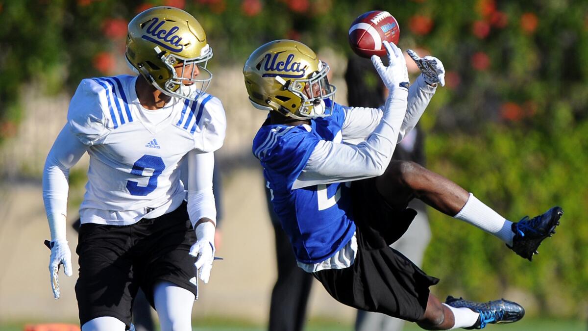 UCLA defensive back Denzel Fisher deflects a pass intended for receiver Cordell Broadus (9) during spring practice.