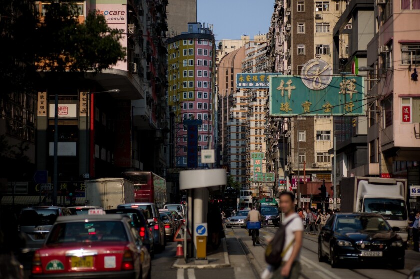 A man crosses a busy street in Hong Kong.