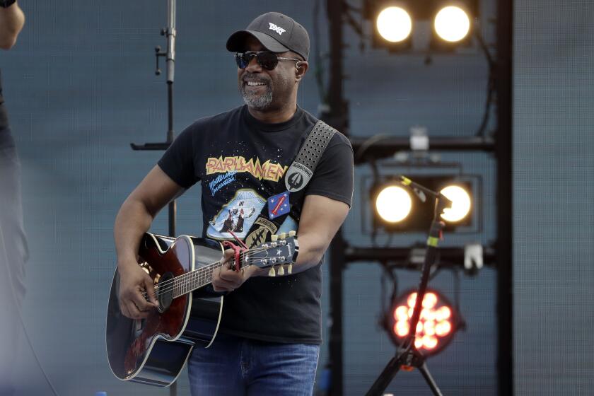 FILE - Singer Darius Rucker takes part in a concert before the NASCAR Daytona 500 auto race Sunday, Feb. 16, 2020, at Daytona International Speedway in Daytona Beach, Fla. While singer/songwriter Darius Rucker notes that pretty much all athletes “want to be singers and all singers want to be sports guys,” the biggest similarity is how they all need to mesh with teammates. Or bandmates. (AP Photo/Chris O'Meara, File)