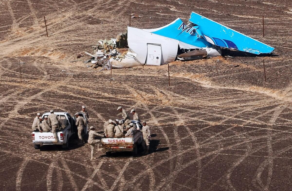 Egyptian officials on Nov. 1 approach wreckage of a Russian passenger jet that crashed near Hassana, Egypt.