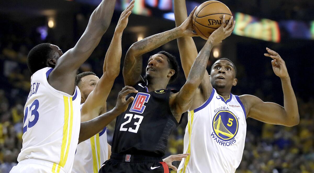 Clippers guard Lou Williams draw three defenders while attempting a shot during Game 1 on Saturday in Oakland.