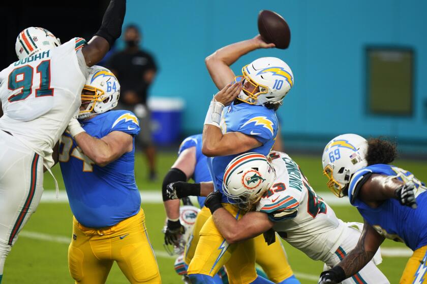 Los Angeles Chargers quarterback Justin Herbert (10) attempts to throw a pass under pressure from Miami Dolphins outside linebacker Andrew Van Ginkel (43) during the first half of an NFL football game, Sunday, Nov. 15, 2020, in Miami Gardens, Fla. (AP Photo/Wilfredo Lee)