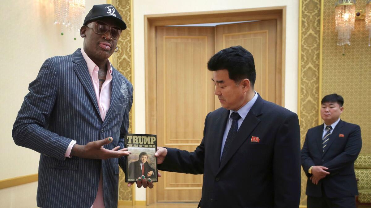 Dennis Rodman, left, presents Donald Trump's book "The Art of the Deal" to North Korea's Sports Minister Kim Il Guk on June 15 in Pyongyang, North Korea.