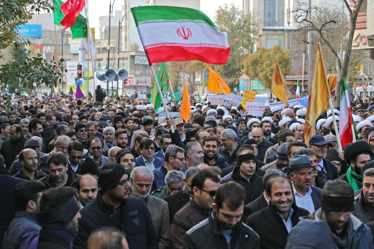 Iranians wave a national flag in support of the Islamic republic's government and supreme leader, Ayatollah Ali Khamenei, in the city of Ardabil, as President Hassan Rouhani said citizens had defeated an "enemy conspiracy" behind a wave of violent street protests.