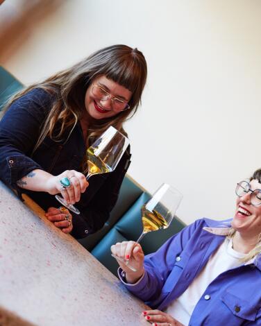 The Ruby Fruit co-owners Mara Herbkersman and Emily Bielagus laugh over a glass of wine