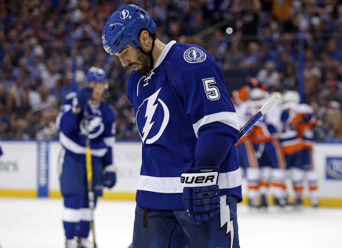 Lightning defenseman Jason Garrison (5) reacts as members of the New York Islanders celebrate a goal during the first period in Game 1.