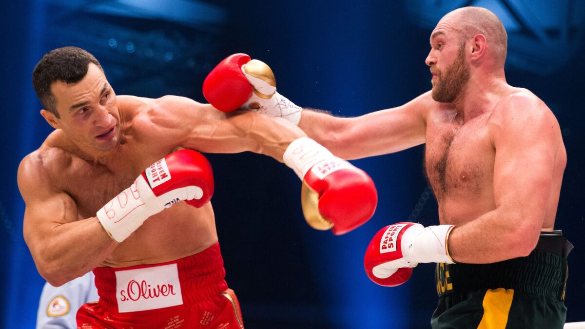 Wladimir Klitschko, left, and Tyson Fury trade punches during their heavyweight title fight Saturday.