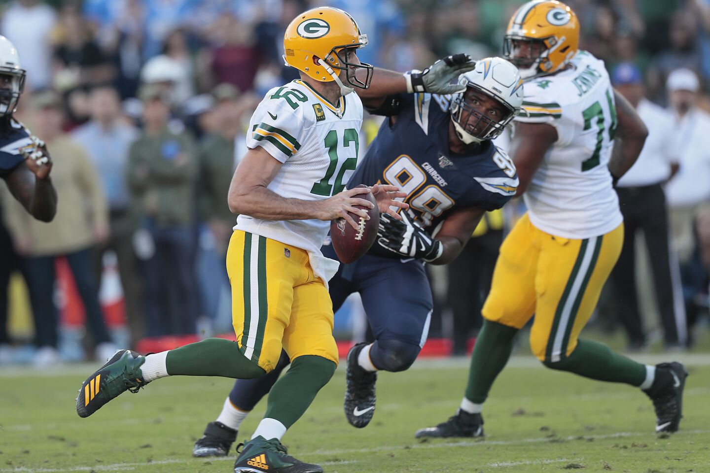 Packers quarterback Aaron Rodgers scrambles past Chargers defensive tackle Jerry Tillery.