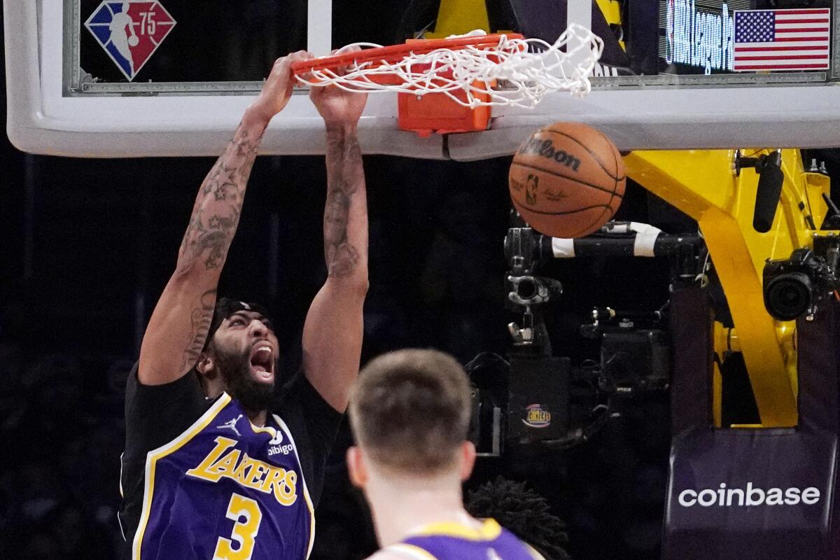 Lakers forward Anthony Davis dunks over Jazz guard Austin Reaves.