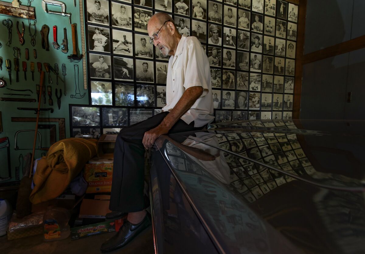Stan Williams sits next to a wall of photos of himself and former teammates in the garage of his Lakewood home.