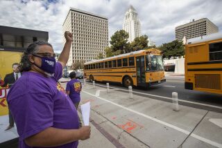 LOS ANGELES, CA - AUGUST 13: Max Arias, SEIU Local 99 Executive Director cheers on school buses as they caravan around the Federal Building in downtown Los Angeles where a press conference was held to demand that Congress and California legislators provide sufficient funding to ensure all students have all the support they need for distance learning and the eventual safe return to -in-person classes. (Mel Melcon / Los Angeles Times)