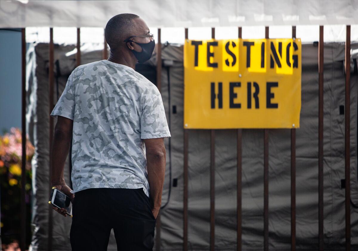 A man waits outside Kedren Community Health Center in South Los Angeles where walk-up coronavirus testing was offered Tuesday.