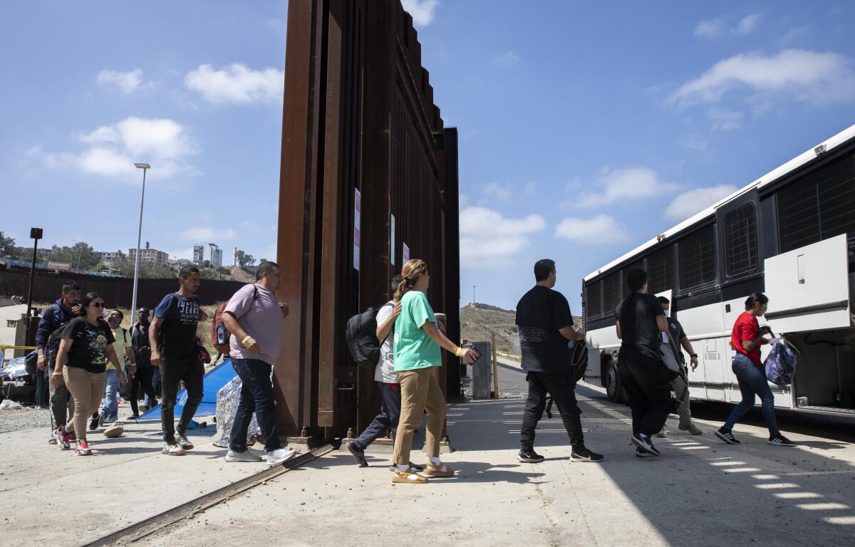 Des migrants embarquent dans un bus pour être traités après avoir été coincés entre les murs frontaliers entre les États-Unis et le Mexique, le 13 septembre 2023.