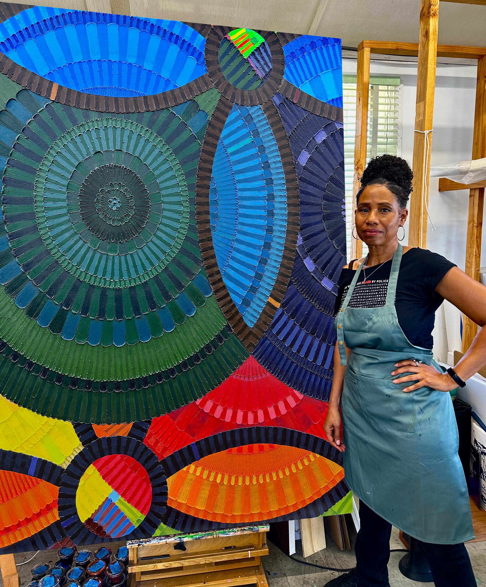 June Edmonds standing next to her artwork "Affirmation."