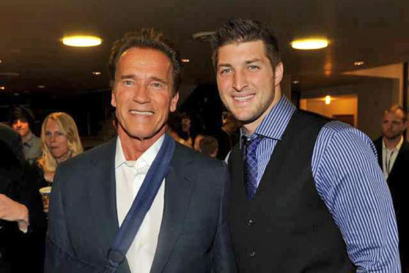 Arnold Schwarzenegger and Tim Tebow arrive at the premiere of "Act Of Valor" held at ArcLight Cinemas in Hollywood on Monday.