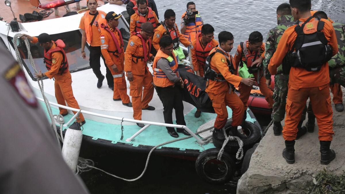 Indonesian search and rescue workers carry a victim's body after a ferry sinking at Tigaras port in Lake Toba, North Sumatra, on Wednesday.