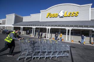 PALMDALE, CA - DECEMBER 18, 2020:An employee at Food 4 Less in Palmdale returns shopping carts outside the store where there have been 22 confirmed cases of COVID-19 in the past 2 weeks at this location. (Mel Melcon / Los Angeles Times)