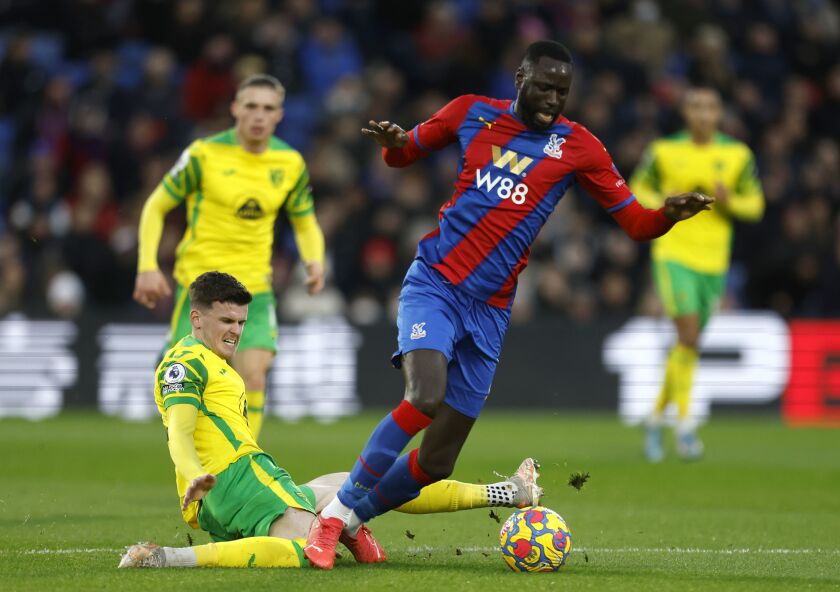 Crystal Palace's Cheikhou Kouyate, right, and Norwich City's Sam Byram battle for the ball during the Premier League match between Crystal Palace and Norwich City at Selhurst Park, London, Tuesday Dec. 28, 2021. (Steven Paston/PA via AP)